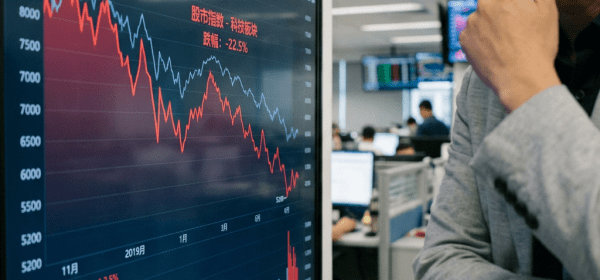 Stock market graph showing a decline with red and blue trend lines and volume bars