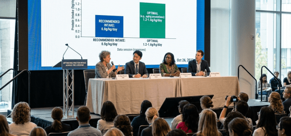 Panelists discussing protein intake guidelines versus optimal needs with bar chart